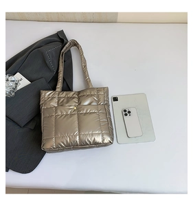 Flat lay of champagne gold quilted tote bag with tablet and smartphone for commute