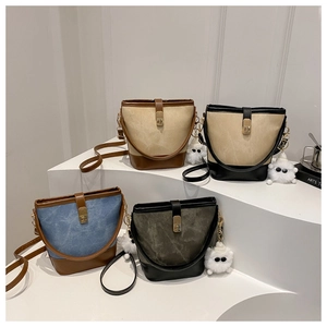Detail of four multi-color canvas bucket bags with leather trim and plush monster charms
