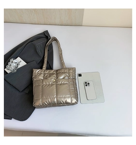 Detail of champagne gold quilted tote bag with metallic finish and long shoulder strap