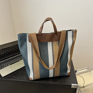 Macro shot of durable canvas tote bag featuring blue and brown vertical stripes in an office