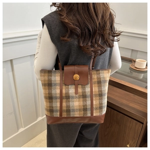 Dettaglio della borsa tote vintage a scacchi con cinturino in pelle e fibbia