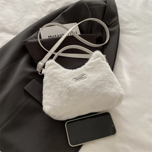 Détail d'un sac à main en fausse fourrure blanche avec plaque sport et texture douce