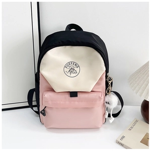 Close-up of color-block backpack with XUEFENG logo and white plush ball charm detail