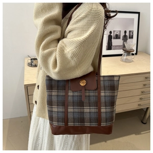 Dettaglio della borsa tote a quadri vintage con patta in pelle marrone e fibbia in metallo N