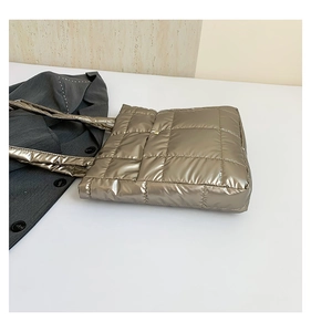 Macro view of champagne gold quilted tote bag with metallic fiber and square stitching