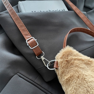 Détail du sac bandoulière en peluche marron avec sangle en cuir et boucle en métal argenté