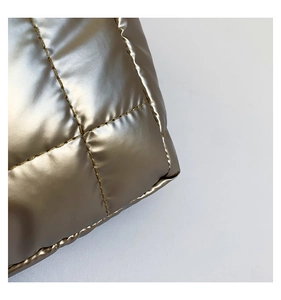 Detailed close-up of champagne gold quilted nylon texture on a large capacity tote bag