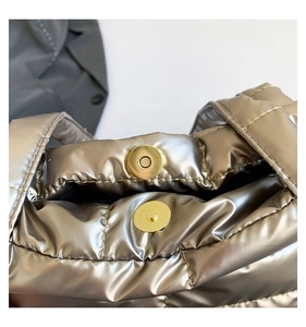 Macro shot of magnetic closure on a metallic gold quilted tote bag with puffer detail