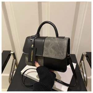 Detail of small square bag featuring black leather and grey tweed patchwork textures