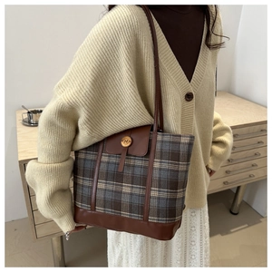 Dettaglio della borsa tote a righe con spalline in pelle e logo metallico N chic