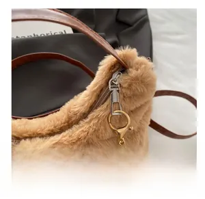 Détail de la fermeture éclair argentée et matériel doré sur le sac fourre-tout en peluche