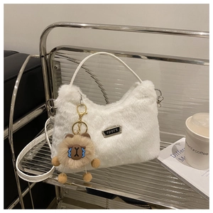 Détail du sac à main en peluche blanche avec étiquette sport et charm capybara doux
