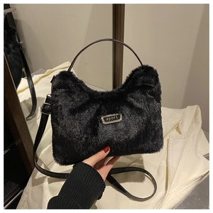 Détail du sac croissant en peluche noire avec plaque sport et bandoulière en cuir