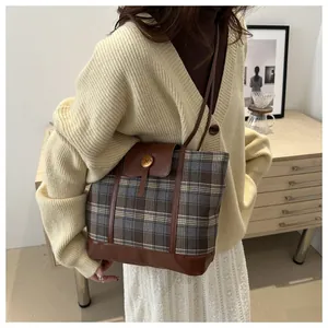Dettaglio borsa tote vintage a quadri con finiture in pelle marrone e fibbia in metallo