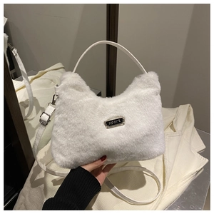 Gros plan du sac croissant en fausse fourrure blanche avec plaque en métal sport