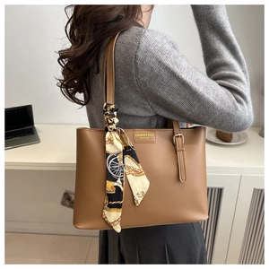 Brown leather tote bag featuring a decorative patterned silk scarf and gold brand plaque