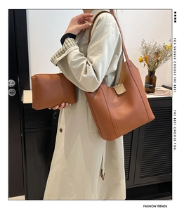 Brown tote bag and matching pouch set shown on model in a minimalist urban setting