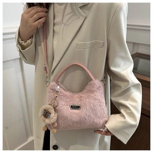 Détail du sac à main rose en peluche avec pendentif lion et bandoulière réglable