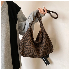 Detail of leopard print canvas hobo bag showing texture, wide strap and metal hardware