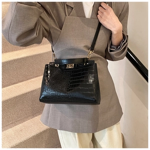 Détail du sac à main noir gaufré croco avec fermoir doré rotatif et bandoulière réglable
