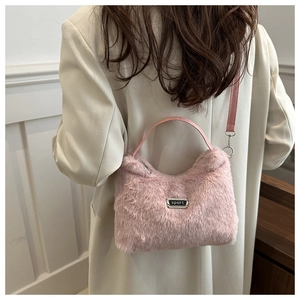 Sac bandoulière en fausse fourrure rose avec logo sport porté par le mannequin