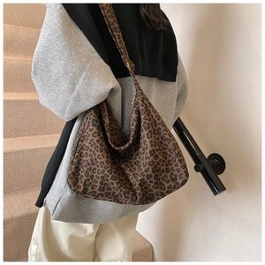 Detailed view of the large leopard print bucket bag with adjustable wide shoulder strap