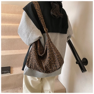 Close-up of leopard print canvas tote bag showing textured fabric and wide shoulder strap