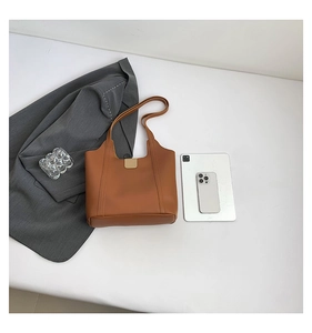 Brown leather tote bag featuring a magnetic clasp, perfect for holding a tablet and essentials