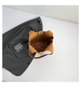 Detailed interior view of a brown tote bag with light gold magnetic buckle closure