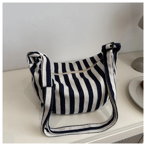 Detailed macro view of the blue and white vertical striped canvas bag with adjustable strap