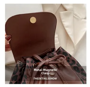 Détail d'un sac seau léopard avec boucle magnétique en métal et fermeture par cordon