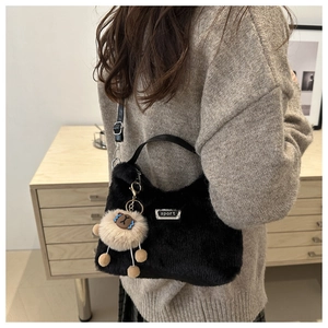 Vue détaillée du sac à main en peluche noire avec breloque mouton et logo sport