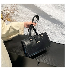 Nahaufnahme einer schwarzen Lackledertasche mit einer glatten goldenen Metallschnalle