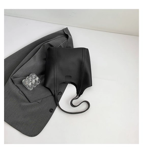 Minimalist black matte tote bag with vertical straps and magnetic flap on white background