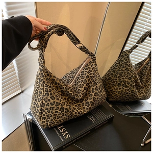 Detail of leopard print canvas tote bag featuring wide strap and secure zipper closure