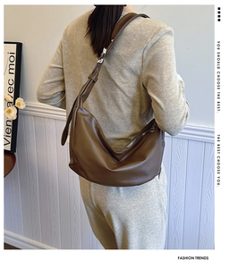 Detail view of a large coffee brown hobo bag with matte leather texture and adjustable strap