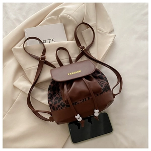Close-up of brown leather mini backpack with leopard print panels and fashion lettering