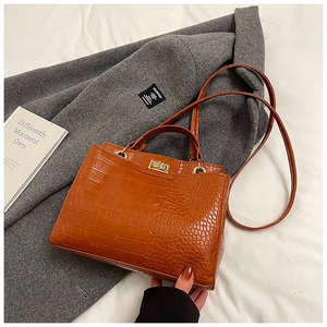 Détail du sac à main marron orangé embossé crocodile avec fermoir doré et bandoulière fine
