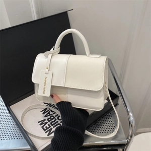 Minimalist white paneled satchel bag with top handle and detachable crossbody strap
