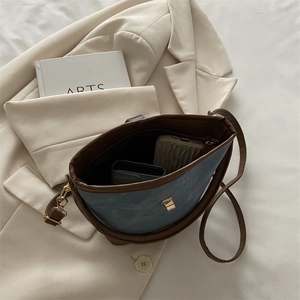 Retro contrast shoulder bag in navy blue with brown leather trim and interior storage