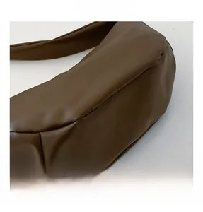Close-up of brown crescent bag showing fine leather texture and neat bottom stitching