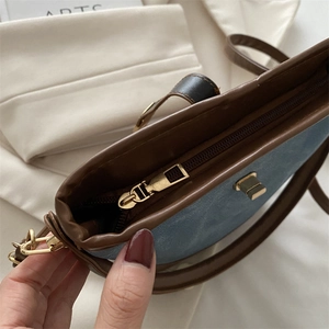 Retro blue canvas bucket bag with brown leather trim and golden metal lock details