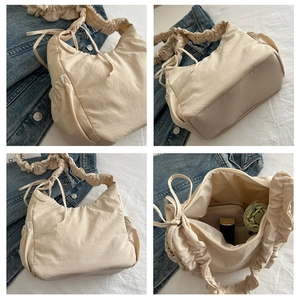 Detailed interior view of a cream gathered shoulder bag showing large storage capacity