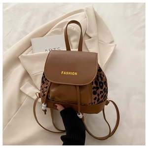 Detail of drawstring closure and leopard print patchwork on brown leather backpack
