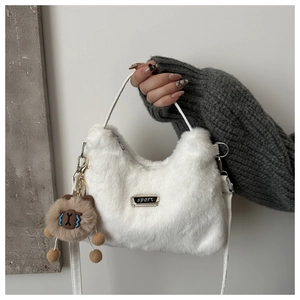 Détail du sac bandoulière blanc en peluche avec plaque Sport et breloque marron mignonne