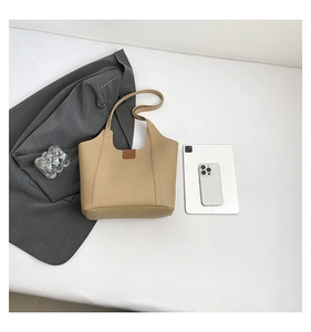 Minimalist beige leather tote bag with flat lay styling and professional office accessories