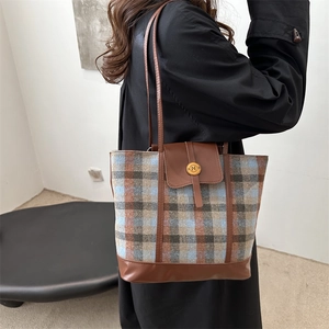 Borsa tote retrò a quadri blu con finiture in pelle marrone indossata da modella