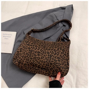 Close-up of leopard print canvas tote with adjustable strap and metal zipper detail