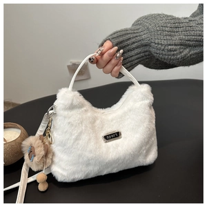 Détail du sac à main en peluche blanche avec bandoulière et pendentif lion marron
