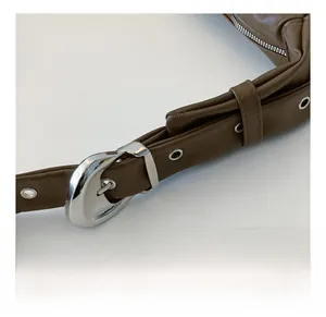 Close-up of adjustable brown leather shoulder strap with polished silver metal horseshoe buckle